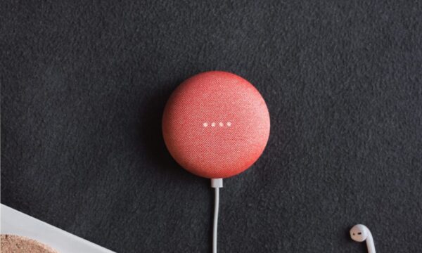 flat lay photography of coral Google Home Mini on black surface beside Apple AirPods